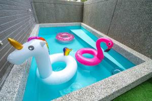 einem Pool mit zwei aufblasbaren Flamingos und einem Pool, der angeregt wird in der Unterkunft Jingchao B&B in Zhuangwei