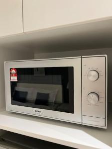 a microwave oven sitting on top of a shelf at The Urban Right at Horizon Suites KLIA in Kampong Melot
