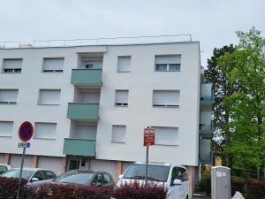 a white building with cars parked in front of it at F2 möblierte 2,5 Zimmer - Wohnung 60 m2 in Saint-Louis