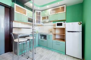 cocina con armarios verdes y nevera blanca en Kvartirkoff na Obolonskom 40, en Kiev