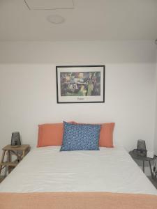 un letto con cuscini arancioni e blu sopra di Romantic Studio a Vila do Conde Altre 5 foto