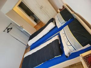 a blue bed with black and white pillows at F2 möblierte 2,5 Zimmer - Wohnung 60 m2 in Saint-Louis