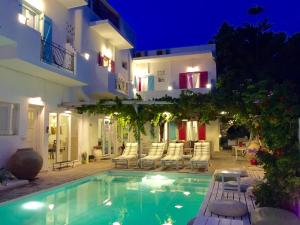 a swimming pool in front of a house at night at Aphrodite Boutique Hotel in Aliki
