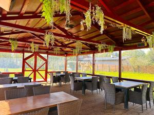 uma área de refeições com mesas e cadeiras num pavilhão em Čill Easy hotel with self check-in em Ādaži