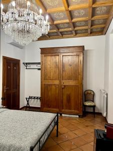 a bedroom with a wooden cabinet and a chandelier at Domus Giovanna in Rome