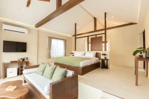 ein Schlafzimmer mit einem Bett und einem Sofa in einem Zimmer in der Unterkunft Malaya Villa Kohlarn in Ko Larn