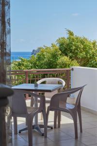 uma mesa e cadeiras numa varanda com o oceano em Thea apartments em Xerokampos