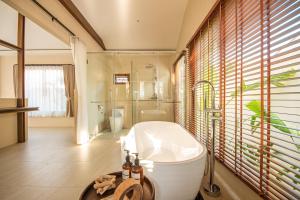 uma casa de banho com uma banheira, um chuveiro e um WC. em Malaya Villa Kohlarn em Ko Larn