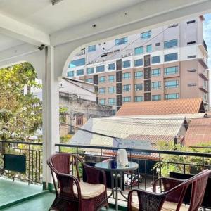 un balcón con sillas y una mesa y un edificio en Saysouly Guest House, en Ban Nongdouang