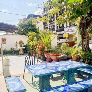 Saysouly Guest House في Ban Nongdouang: طاولة وكراسي زرقاء والنباتات الفخارية