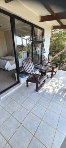 two chairs and a bed on a patio at Greystone Guesthouse in Jeffreys Bay