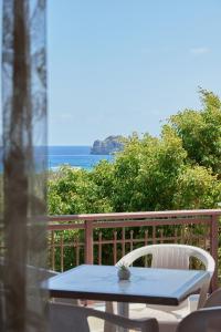una mesa y sillas en un balcón con vistas al océano en Thea apartments, en Xerokampos