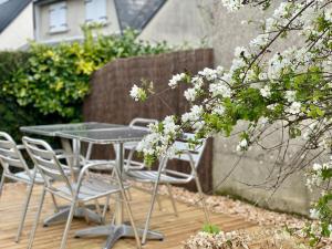 バイユーにあるLa maison des Declos avec parking privéの白い花が咲いたパティオのテーブルと椅子 +28枚の写真