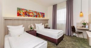 a hotel room with two beds and a desk at Best Western Hotel Bad Rappenau in Bad Rappenau +54 photos