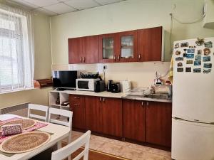 uma cozinha com armários de madeira e um frigorífico branco em Аврамов дом - етаж от къща em Veliko Tarnovo