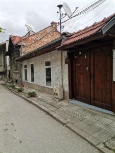 a couple of buildings with wooden doors on a street at Аврамов дом - етаж от къща in Veliko Tŭrnovo
