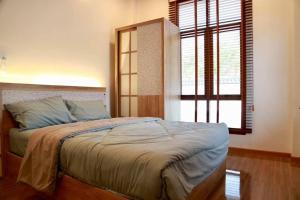 una camera da letto con un grande letto e una finestra di TakaOnzen a Ban Khao Ket