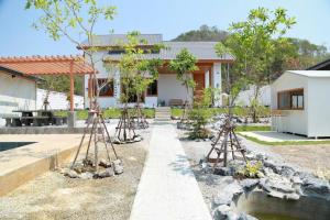 una casa con un giardino alberato e alcune vipere di TakaOnzen a Ban Khao Ket