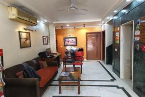 salon z kanapą i stołem w obiekcie Hotel Indraprastha w Nowym Delhi