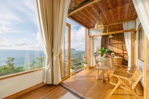 a room with a table and chairs and large windows at U villa in Ban Huai Khai