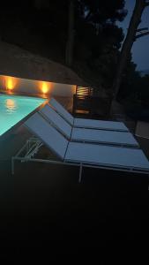 a swimming pool at night with lights in the water at Askalosia villa in Agios Georgios