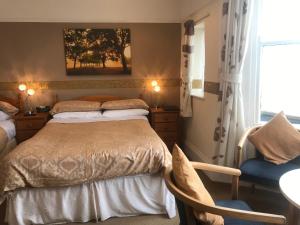 a bedroom with a bed and a chair and a window at The Whiteley in Scarborough