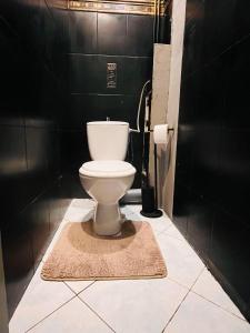 a white toilet in a bathroom with black walls at BESKID HOME in Bielsko-Biała