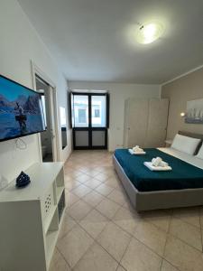 Villa Altomare في أوترانتو: غرفة نوم كبيرة بها سرير وتلفزيون