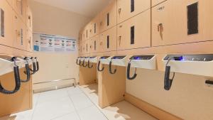 una fila de lavabos en una habitación con armarios en Henn na Hotel Kagoshima Tenmonkan, en Kagoshima