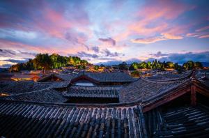 麗江市にある思法特观景客栈 Sifat Viewing Innの夕日を背景にした古い建物