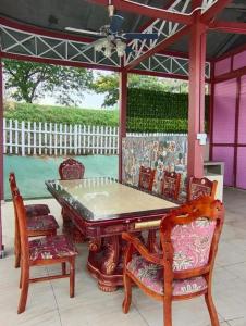 a dining table and chairs on a patio at Mamee Dome Villa Best Homestay in Kampong Alor Gajah