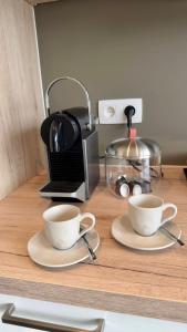 duas chávenas num balcão com comodidades para preparar café em Luxurious flat offering comfort and privacy in Martelange em Martelange