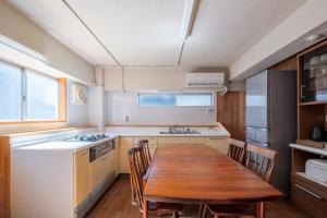 una cucina con tavolo in legno e una sala da pranzo in legno di Smart House Kominka ad Atami