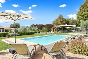 a pool with chairs and umbrellas in a yard at I Sicomori - Seme di Carota - Glamping e appartamenti con piscina a Saturnia in Saturnia