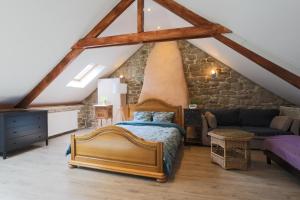 ein Schlafzimmer mit einem Bett und einer Steinmauer in der Unterkunft Gite Relax a la Campagne in Guern