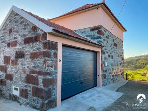 a garage door on the side of a brick building at Raposeira Country House in Calheta