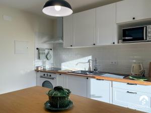 eine Küche mit weißen Schränken und einem Holztisch in der Unterkunft Raposeira Country House in Calheta