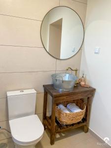 ein Badezimmer mit Toilette, Waschbecken und Spiegel in der Unterkunft Raposeira Country House in Calheta + 35 Fotos