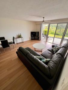 uma sala de estar com um sofá e uma mesa em Hamilton Island Poinciana 008 Ground Floor 2bedrooms Free Buggy em Hamilton Island