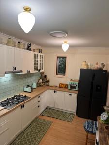 uma cozinha com armários brancos e um frigorífico preto em Lee Manor em Walhalla