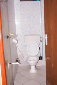 ein Badezimmer mit einem weißen WC in einer Kabine in der Unterkunft Dasha Studio apartment Bamburi D4 in Bamburi