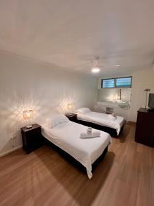 duas camas num quarto com dois candeeiros e um espelho em Hamilton Island Poinciana 008 Ground Floor 2bedrooms Free Buggy em Hamilton Island
