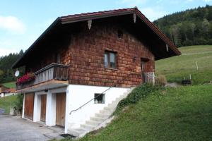 - un petit bâtiment en briques avec un balcon sur une colline dans l'établissement Ferienwohnung Hinterpommern - Chiemgaukarte, à Inzell