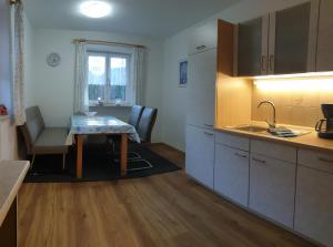 une cuisine avec une table et une salle à manger dans l'établissement Ferienwohnung Hinterpommern - Chiemgaukarte, à Inzell