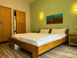 a large bed in a room with green walls at Gaststätte Brauhaus Zwickau GmbH in Zwickau