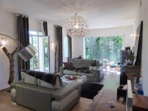 uma sala de estar com um sofá e um lustre em Domaine avec Piscine em Grans