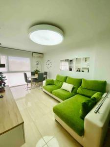 a green couch in a living room with a table at Moderno Dúplex in Malgrat de Mar