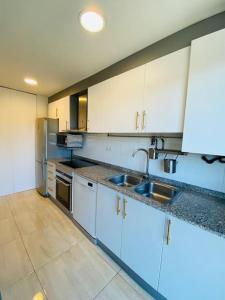 a kitchen with white cabinets and stainless steel appliances at Moderno Dúplex in Malgrat de Mar