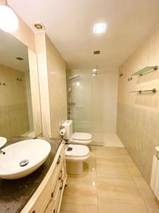 a bathroom with two sinks and a toilet and a shower at Moderno Dúplex in Malgrat de Mar +5 photos