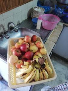 una bandeja de manzanas y plátanos en un fregadero en Jalwa Residential, en Murree